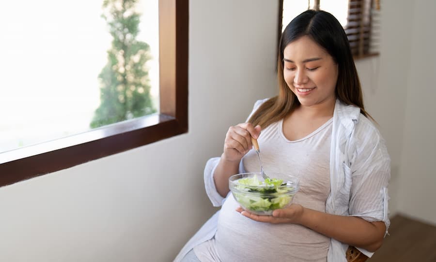 mulher grávida comendo salada
