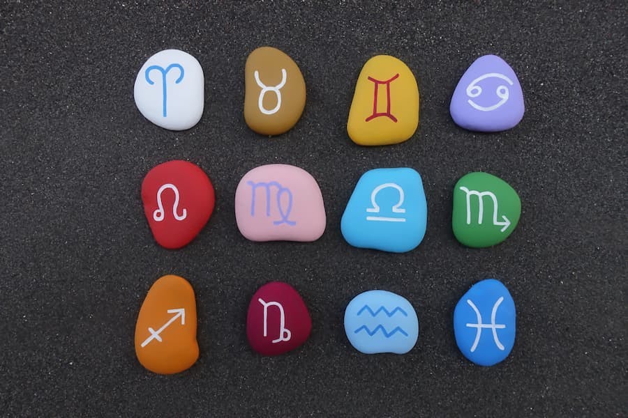 Pedras coloridas pintadas com os símbolos de cada signo