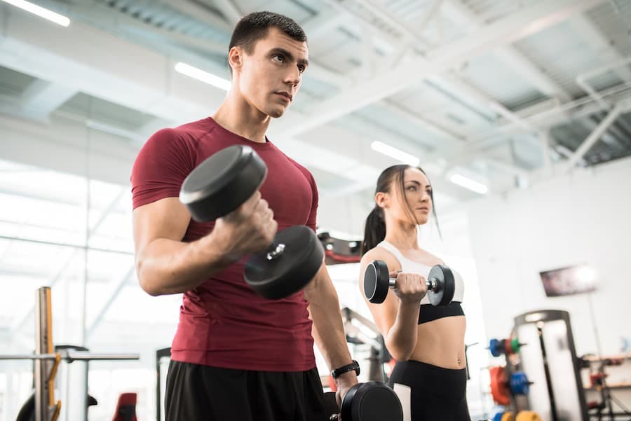 Casal treina musculação na academia